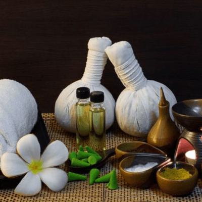 Herbal compress balls and oils, styled for a ritual